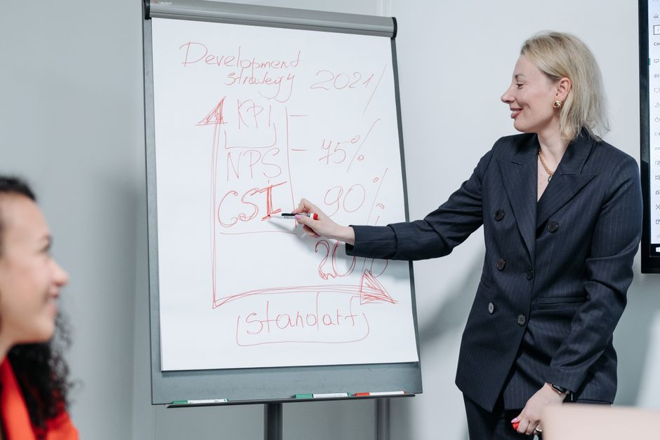 Pessoa de negócios apontando para um painel digital com gráficos de crescimento e KPIs de marketing.