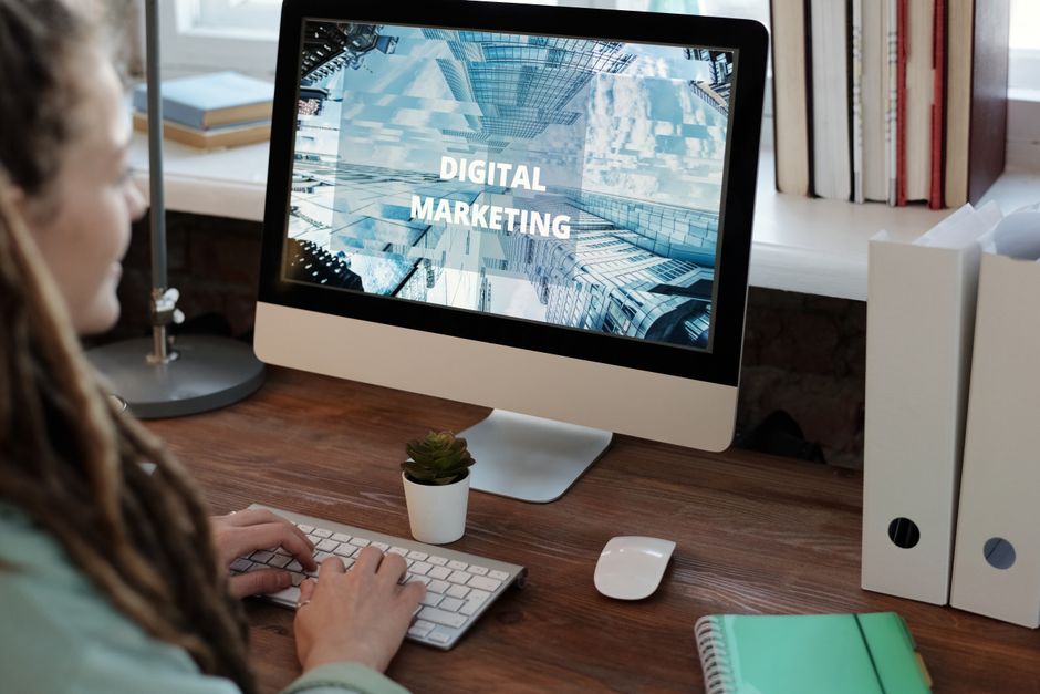 Pessoa digitando em um laptop com ícones de SEO e marketing de conteúdo flutuando ao redor